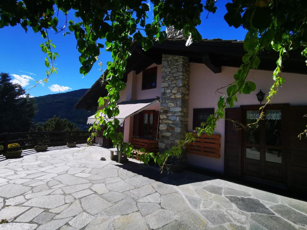una casa en las montañas con una entrada de piedra en La maison de Carmen, en Aosta