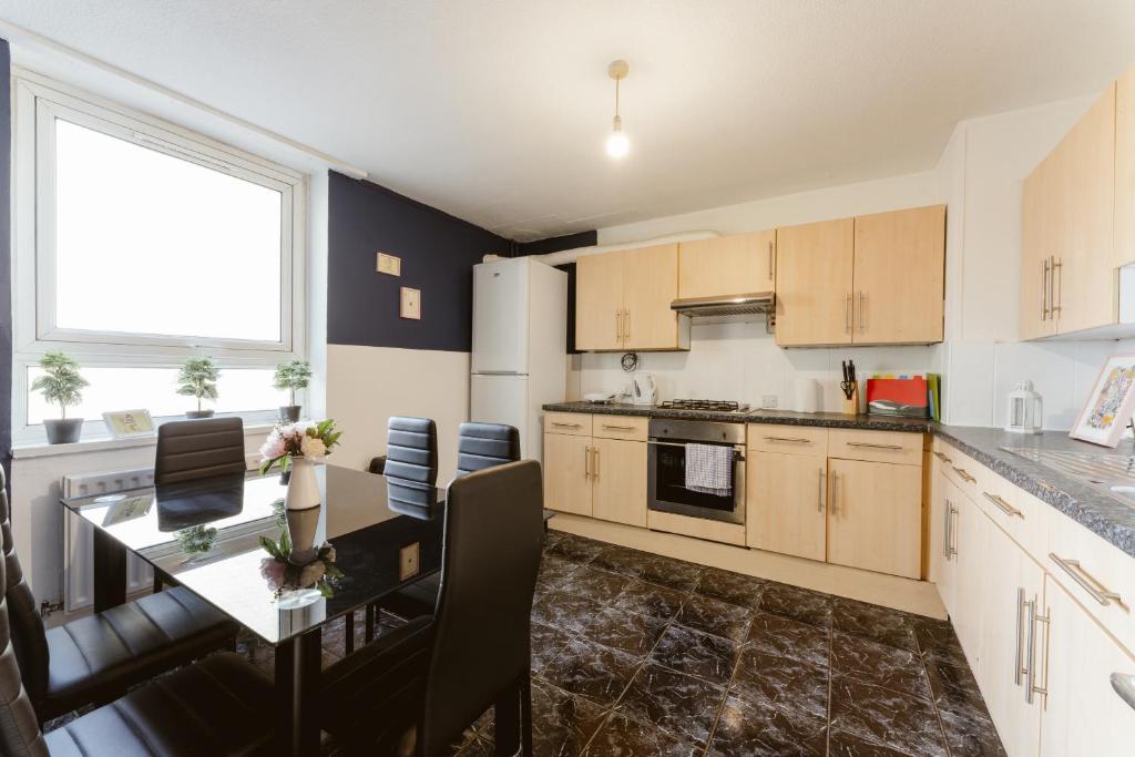 a kitchen with a table and a dining room at Langdon Park DLR beds to stay in London