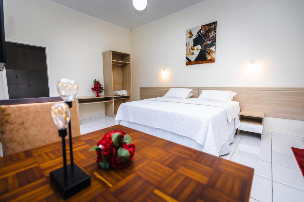 Habitación de hotel con cama y copa de vino en Hotel SPA Paraíso en Cruzeiro do Sul