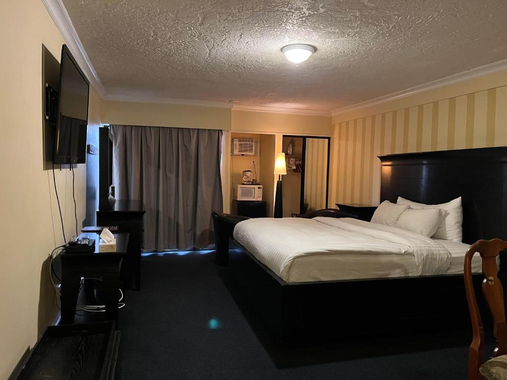 a hotel room with a bed and a television at Island Travel Inn in Victoria