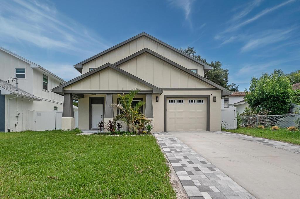a white house with a garage and a driveway at New Construction Located in Ybor City! in Tampa