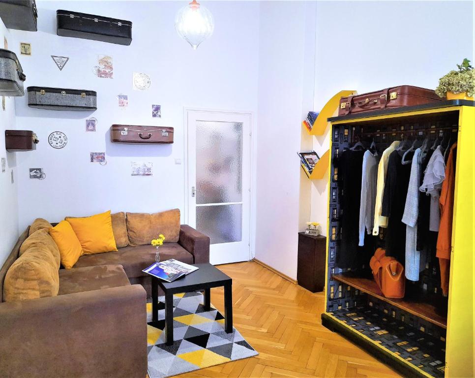 a living room with a couch and a rack of clothes at D16 Apartman in Szentgotthárd