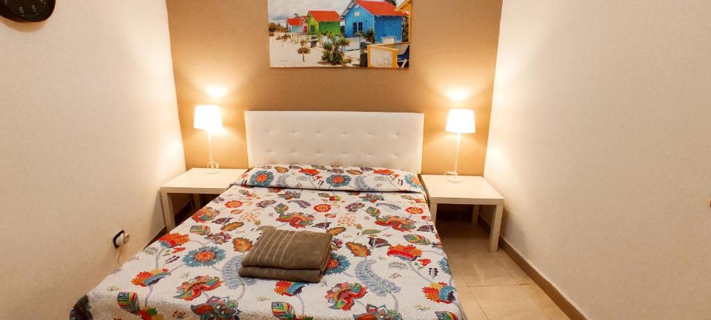 um pequeno quarto com uma cama e duas mesas em Casa TINGUARO em Vecindario