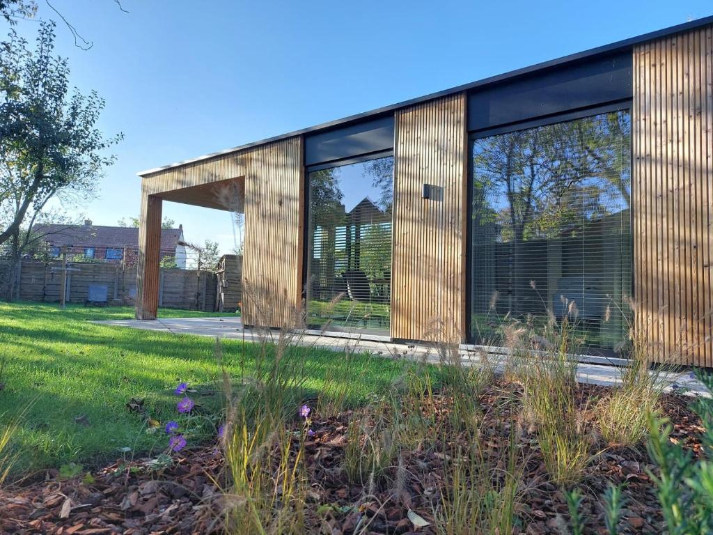 un edificio con grandes ventanas en un patio en Geniet van alle comfort tussen Ieper en Heuvelland, en Ypres