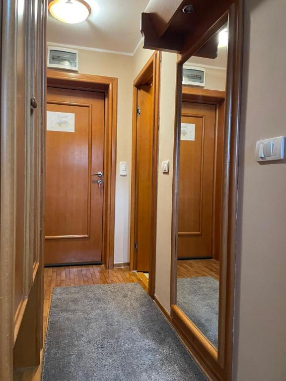 a hallway with two doors and a mirror at Apartman 601 i 603 Kopaonik Centar in Kopaonik