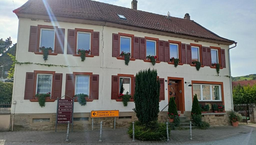 a building with red shutters and a sign in front of it at Urlaub mit Charme in der kleinsten Stadt der Pfalz. in Obermoschel