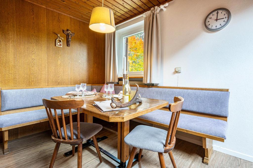 comedor con mesa, sillas y reloj en App Mountain Lanzmaria, en Sorafurcia