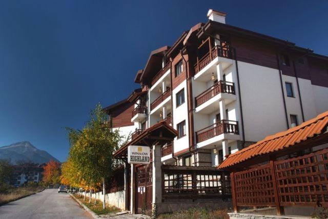 un gran edificio con balcones en el lateral de una calle en Winslow Highland Bansko - Apartment Giovanni, ул Валевица 7 кв Грамадето, en Bansko