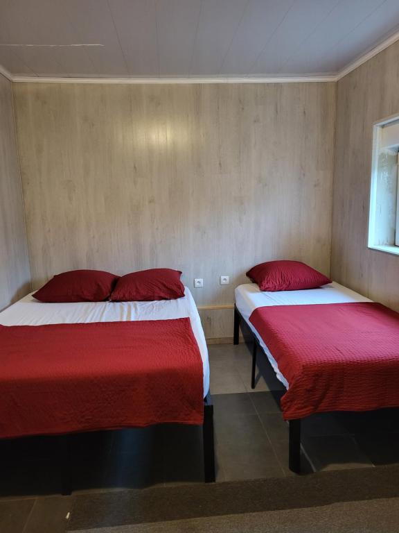 twee bedden in een kamer met rode en witte lakens bij STUDIO ENTRE PARIS et DISNEY 3 in Torcy