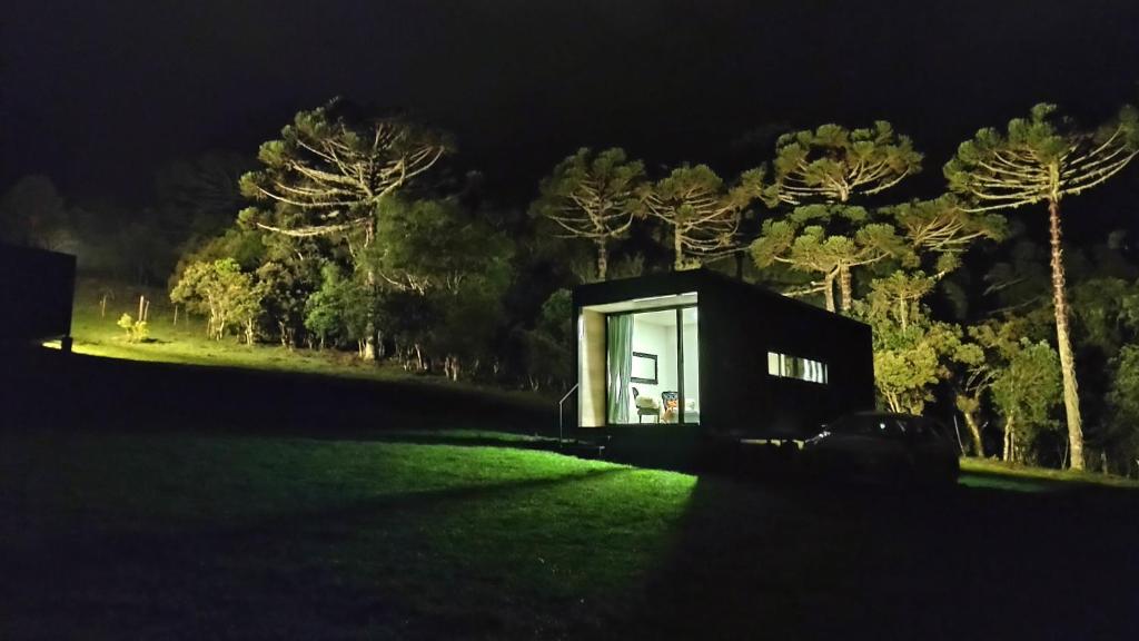 a tiny house in the middle of a field at night at Brumas Casa de Campo - Cambará do Sul in Cambara do Sul