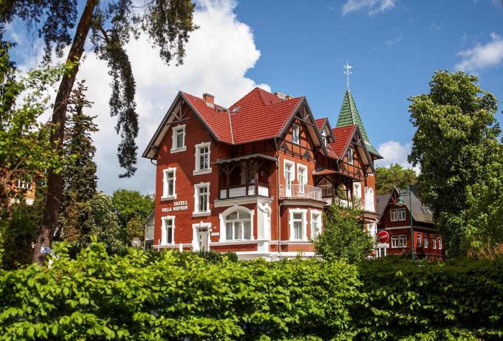ein großes Backsteinhaus mit rotem Dach in der Unterkunft Villa Neptun in Heringsdorf