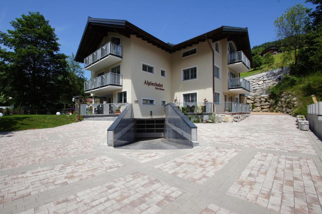 a large building with a courtyard in front of it at Alpinchalet Eder - Steiner in Saalbach-Hinterglemm