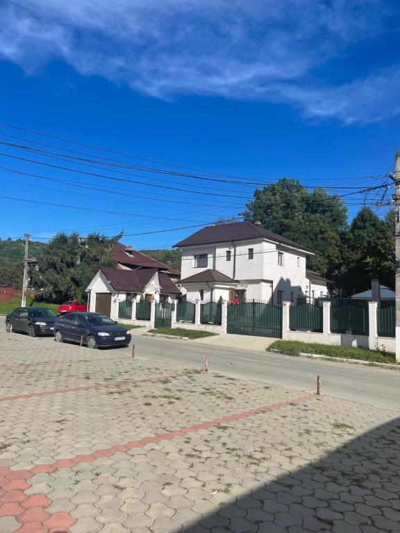 una calle con coches aparcados frente a una casa blanca en Casa Roa en Slănic