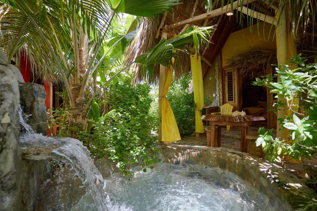 a waterfall in the middle of a garden at CHALET TROPICAL Hotel & Restaurante in Las Galeras