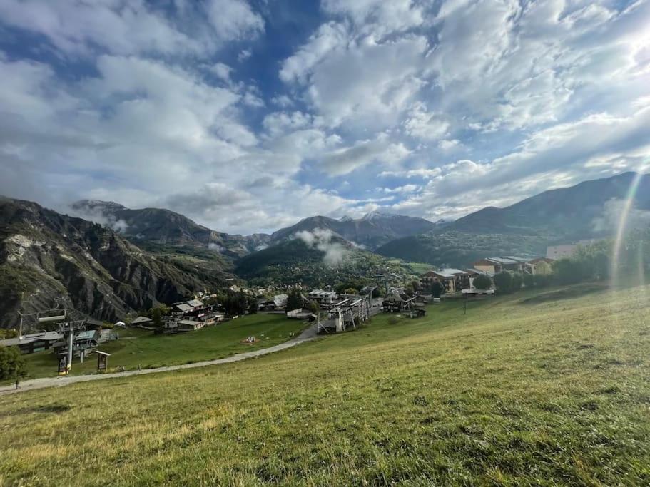 a small village in the mountains under a cloudy sky at Le Seignus d'Allos T2 30m2. Aux pieds des pistes. in Allos