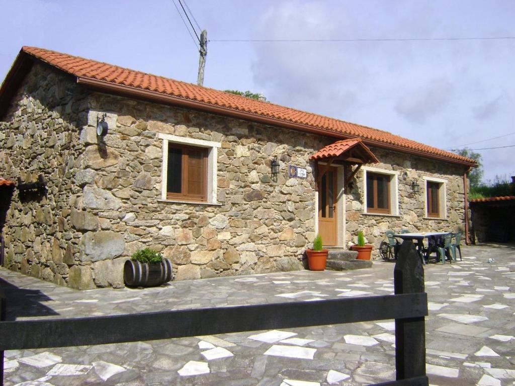 a stone house with a fence in front of it at Stone Cottage FISTERRA in Curtis