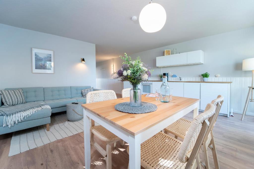 eine Küche und ein Wohnzimmer mit einem Tisch und Stühlen in der Unterkunft Strandkoje Wohnung 7 in Rettin