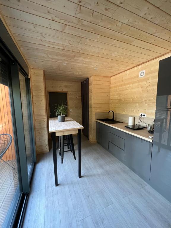 a small kitchen with a table in a room at Chalet 1 contemporain dans son écrin de verdure in Montauban