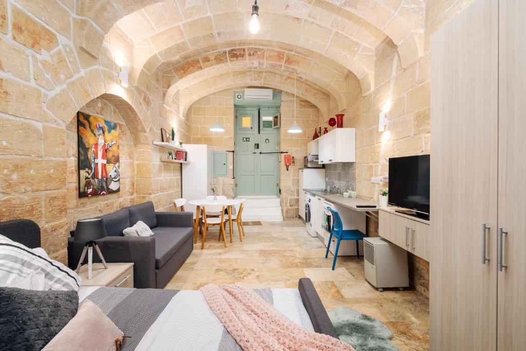 un soggiorno con divano e una sala da pranzo di MCC Suites Valletta a La Valletta