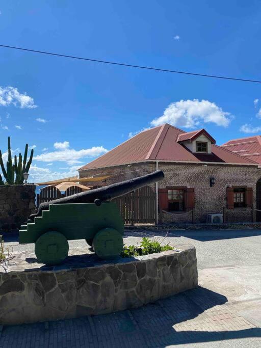 a statue of a gun in front of a building at Barrel House Suite St Eustatius in Oranjestad