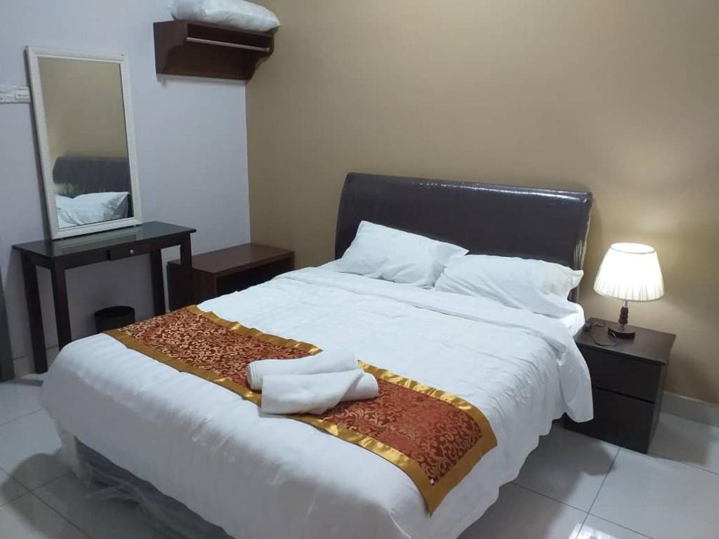 a bedroom with a large white bed with a mirror at Labuan Paragon Apartment - 3 rooms in Labuan