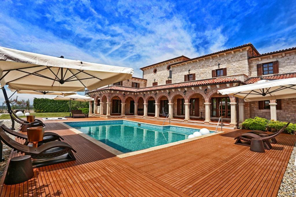 dom z basenem z leżakami i parasolami w obiekcie Villa Carolus-Luxurious Istrian Villa w mieście Barat