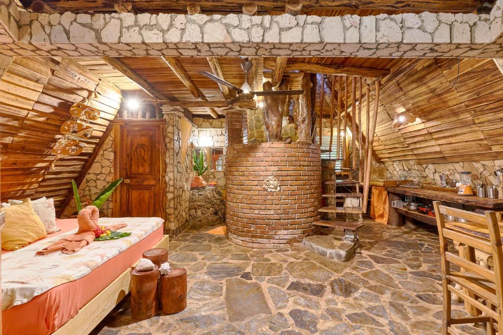 a bedroom with a bed in a wooden room at CHALET TROPICAL Hotel & Restaurant-Pizzeria in Las Galeras