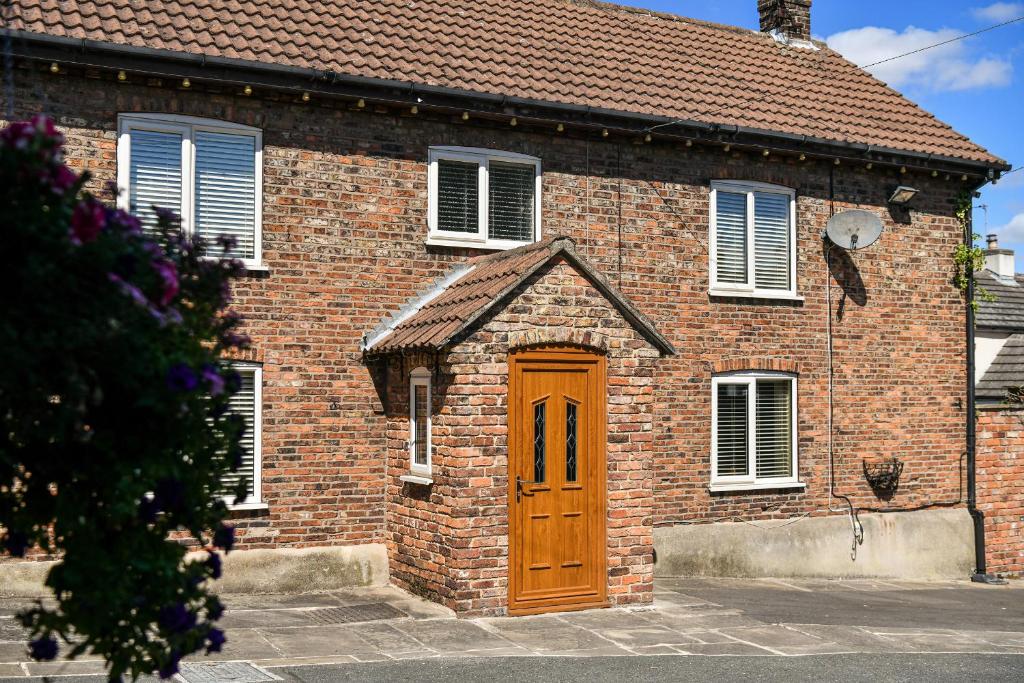 a brick house with a wooden door at Dovecote Farm House in Goole