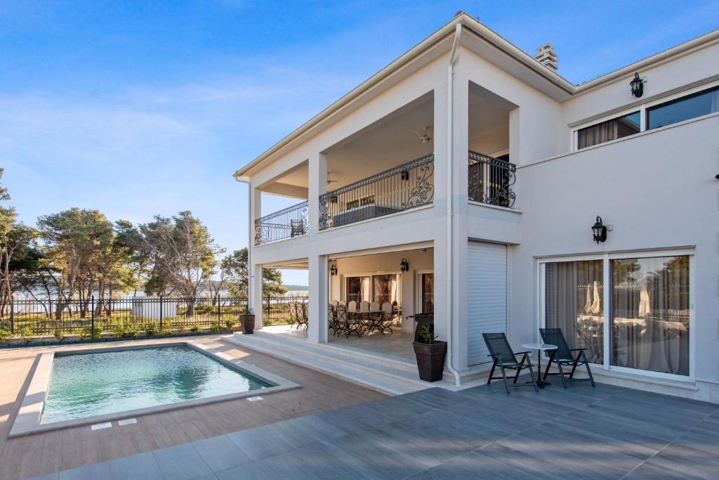 ein Haus mit einem Pool und einer Terrasse in der Unterkunft Villa Carolus-Luxurious Dalmatia Villa in Vodice
