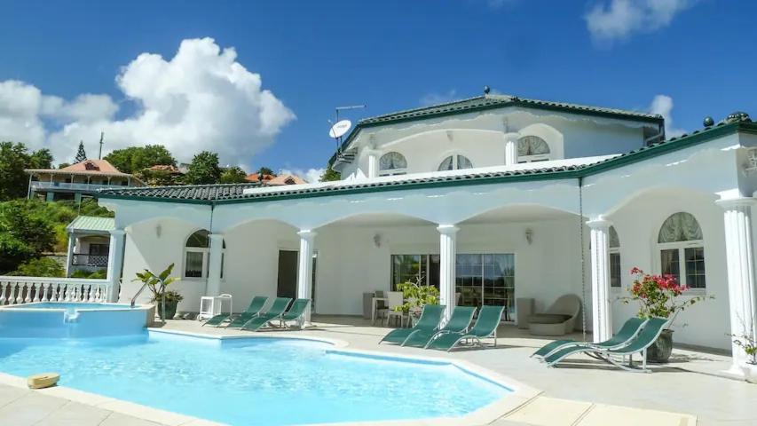 a villa with a swimming pool and a house at Villa Millésime in Le François