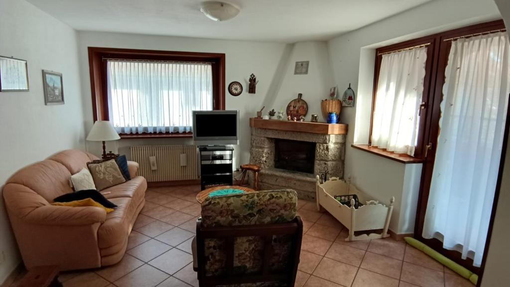 a living room with a couch and a fireplace at Casa Gonano in Prato Carnico