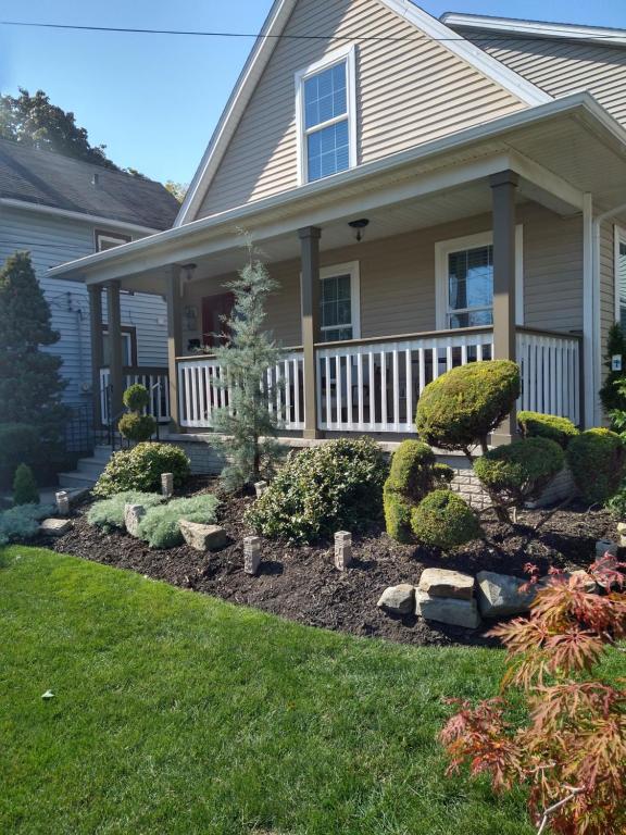 una casa con un porche delantero con jardines en Ecco friendly just like Home en Cleveland