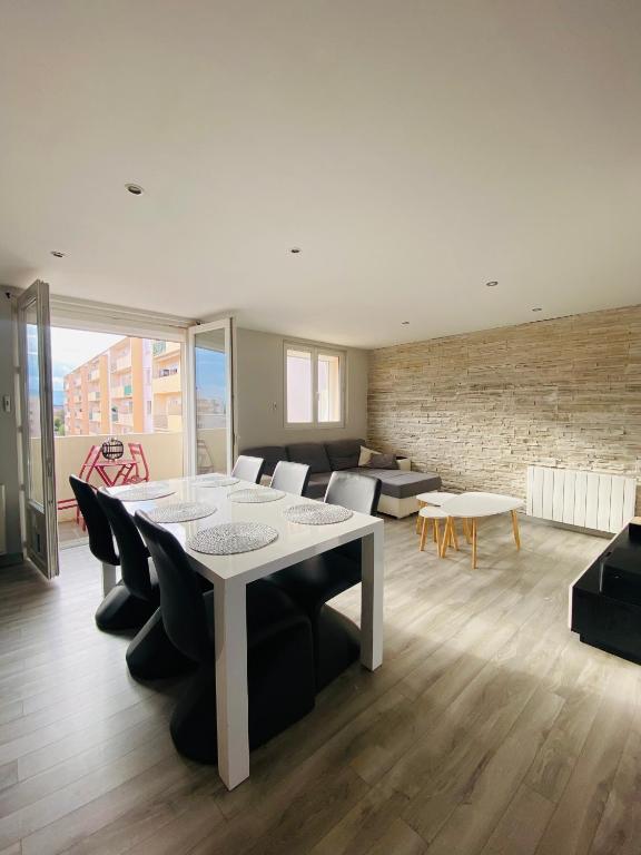 uma sala de estar com uma mesa e cadeiras e um sofá em Appartement - Roanne em Roanne