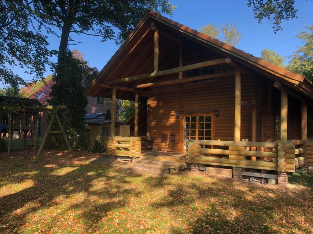 uma cabana de madeira com um banco à frente em House, Wiefelstede-Lehe em Wiefelstede