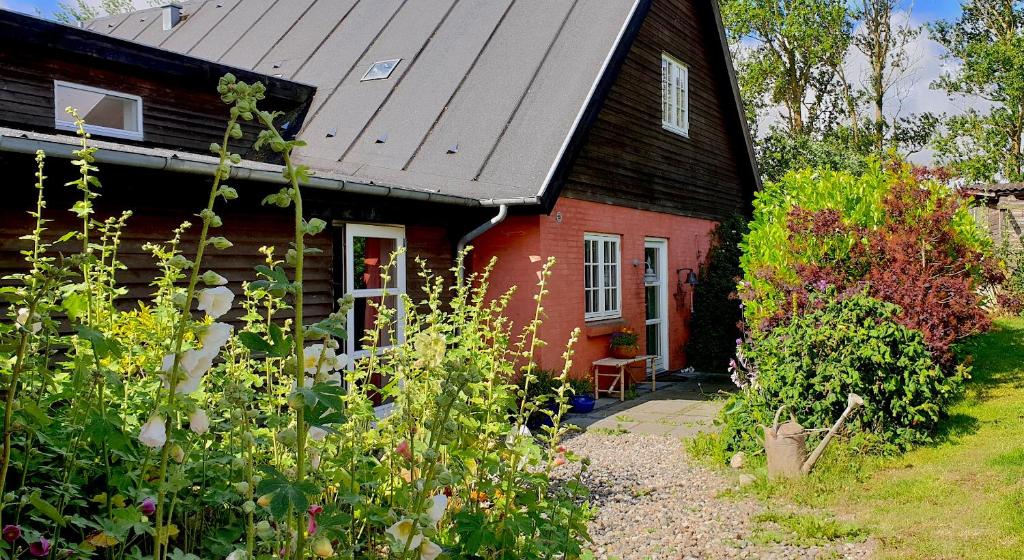 a small red house with a garden in front of it at Farmors Hus in Rude