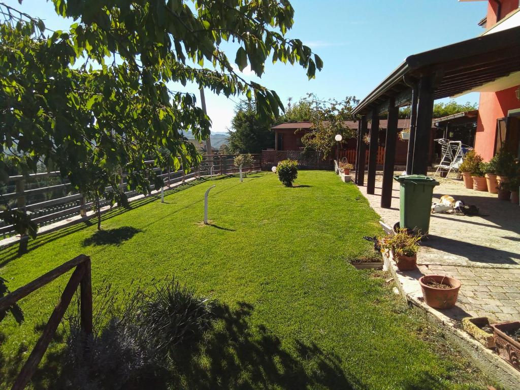 un patio con valla y césped verde en casa ginefra en Tito
