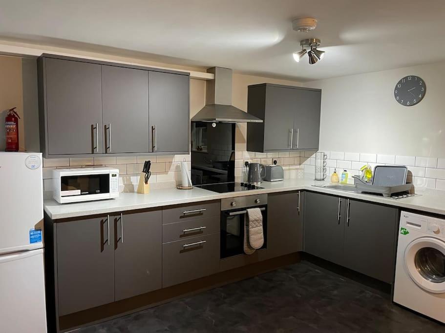 a kitchen with gray cabinets and a washer and dryer at Maple House 2 bed House with free parking in town by ShortStays4U in King's Lynn