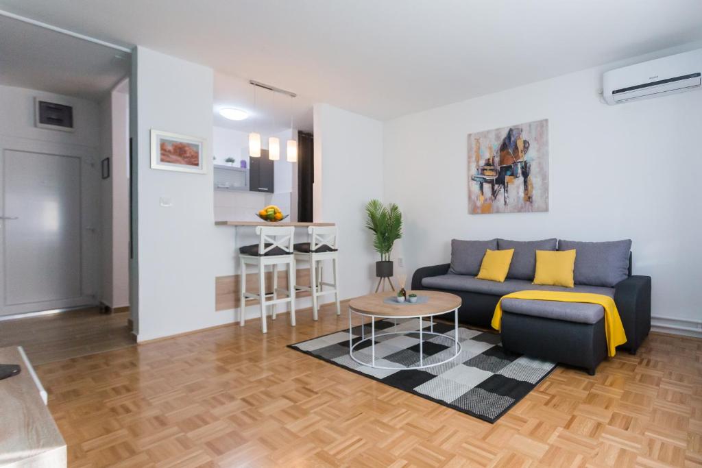 un soggiorno con divano e tavolo di Apartman Lariva a Osijek