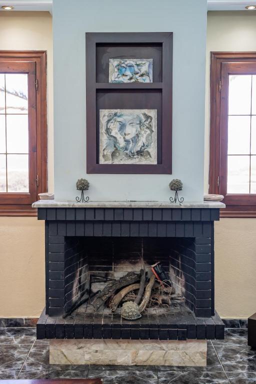 a fireplace in a living room with a fire place at Oceanviewvilla in Karpathos