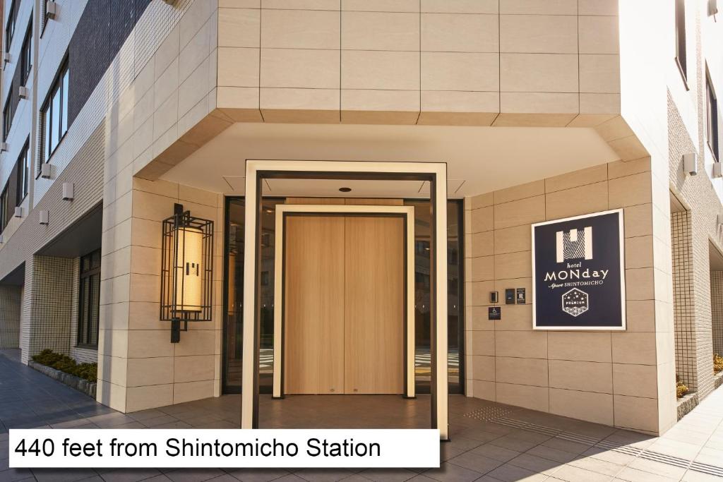 einen Eingang zu einem Gebäude mit einer Holztür in der Unterkunft MONday Apart Premium 銀座新富町 in Tokio