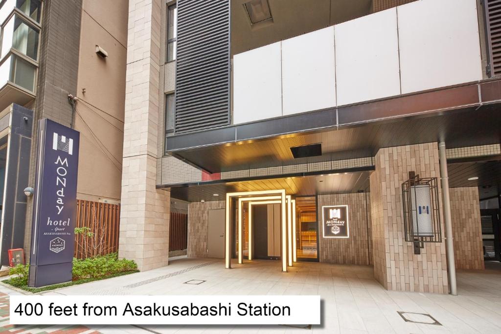 un edificio con una señal delante de él en MONday Apart Premium AKIHABARA ASAKUSABASHI Sta. en Tokio