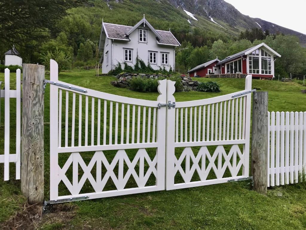 a white fence in front of a white house at Kjosen Lodge, Lyngen. in Lyngseidet
