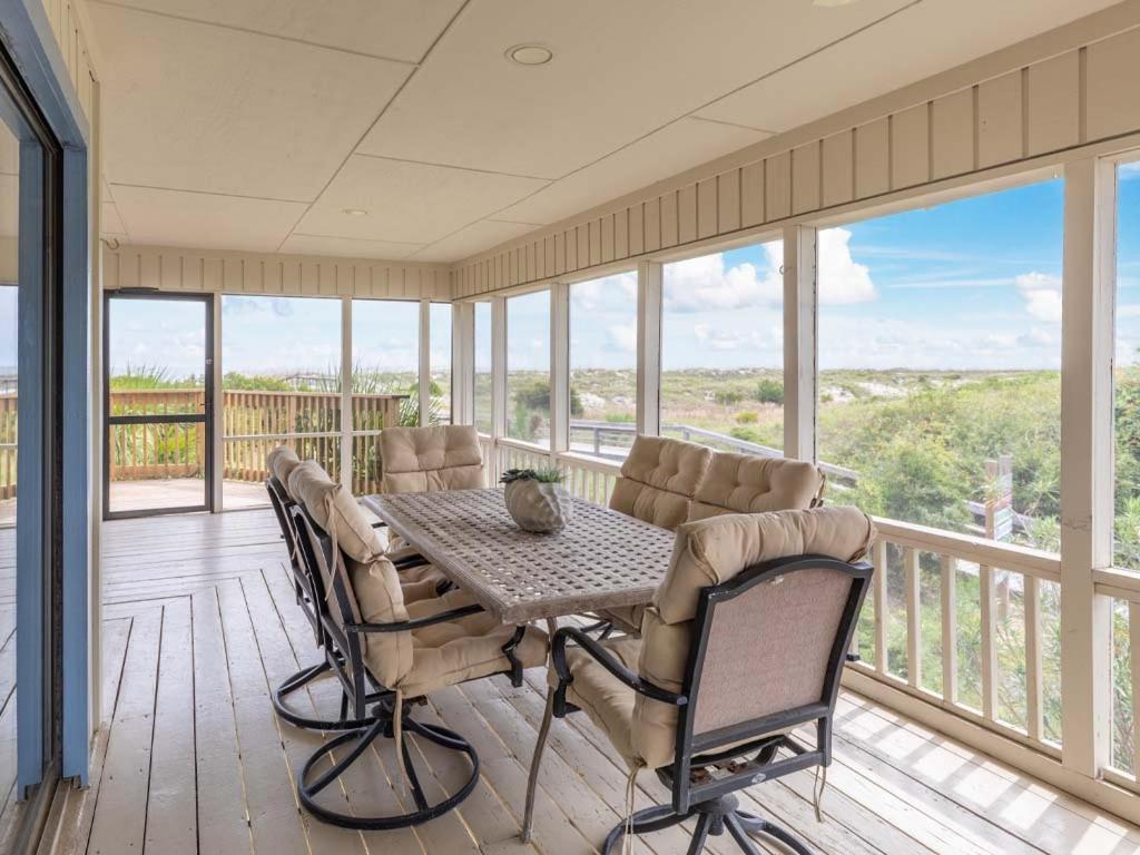 a dining room with a table and chairs on a balcony at Sea Gull Ocean Villa in Tybee Island