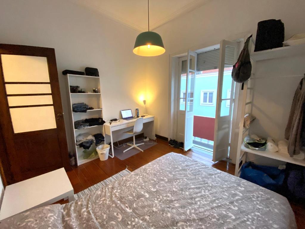um quarto com uma cama e uma secretária com um computador em BREINER 28 no Porto