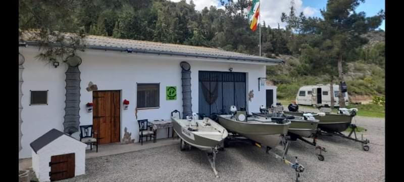 un groupe de bateaux garés devant un bâtiment dans l'établissement R U Ready Fishing, River Ebro, à Mequinenza