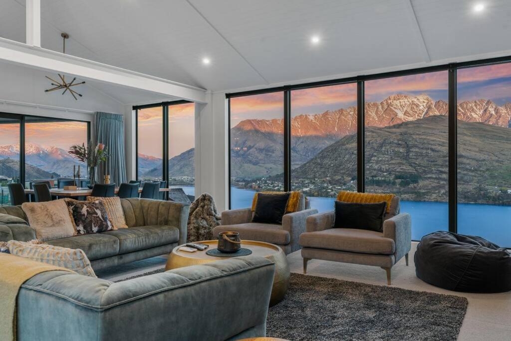 ein Wohnzimmer mit Sofas, Stühlen und Fenstern in der Unterkunft The Ultimate Dream Idyllic Brand New Alpine Home in Queenstown