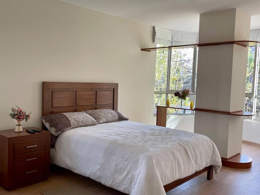 a bedroom with a large bed and a window at Deluxe Department in Cochabamba