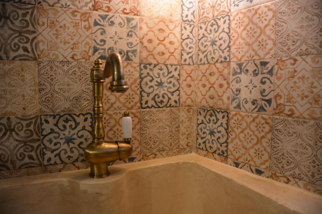 y baño con bañera y fuente de agua. en Lumè en Putignano