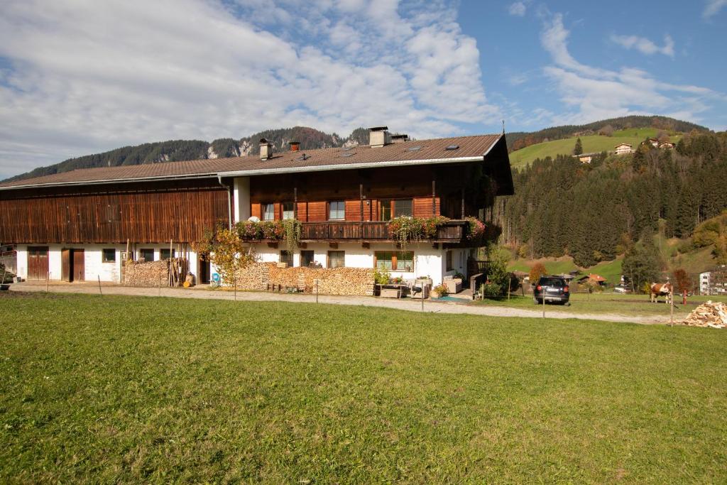 a large house with a green field in front of it at Ferienwohnung zum Mühltal WILD025 in Wildschönau