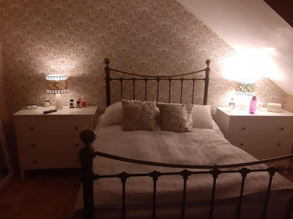 a bedroom with a large bed and two night stands at 3 bedroom townhouse in Liverpool